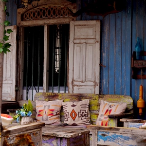 Tables et chaises en bois devant un mur de bois bleu et une fenêtre avec barreaux et volets - France  - collection de photos clin d'oeil, catégorie rues